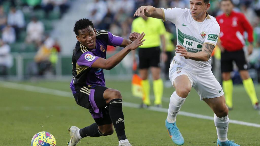 El defensa argentino del Elche Lautaro Blanco (d) disputa el balón ante Gonzalo Plata (i), delantero ecuatoriano del Valladolid.