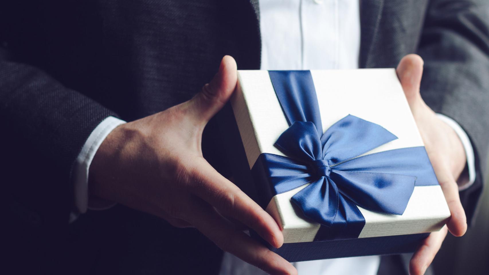 Un hombre, sujetando un regalo.