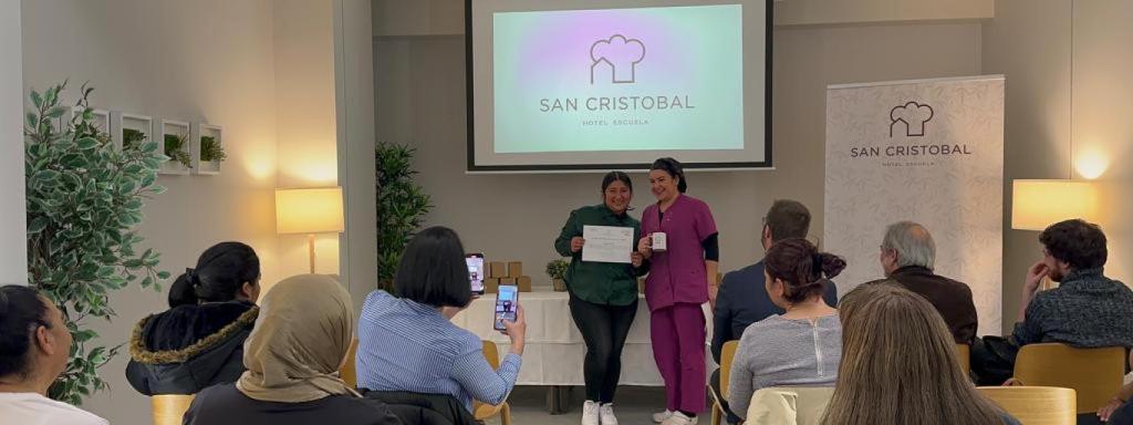 Shirley recibe de una antigua alumna del Hotel que hoy trabaja fija en este establecimiento, el diploma que le acredita para trabajar.