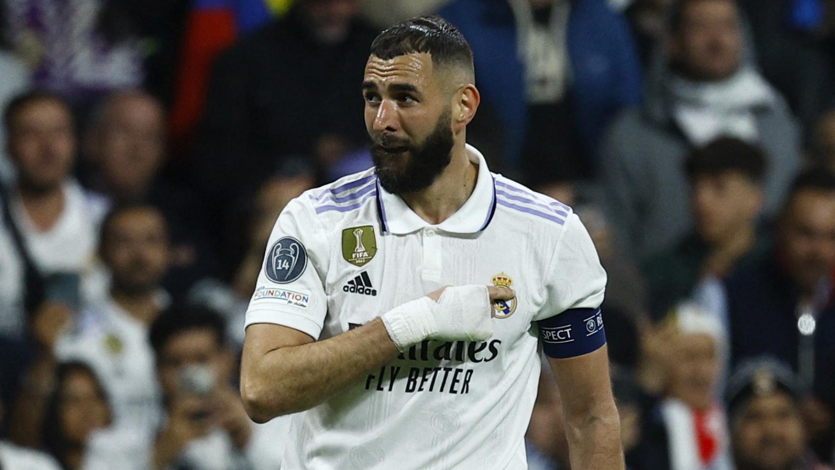 Benzema se señala el escudo del Real Madrid tras marcar.