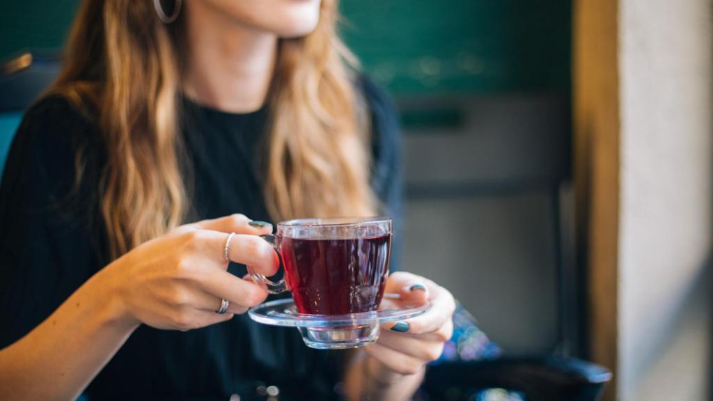 Una mujer, bebiendo una infusión.