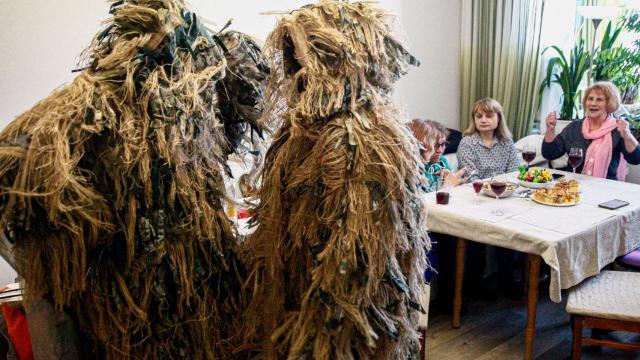 Valentina Todosienko y Julia Julaeva, con dos de los trajes de camuflaje para francotiradores que han confeccionado junto con el resto de mujeres del grupo en Kiev, Ucrania.