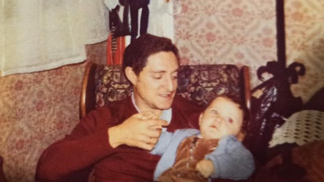Un padre sostiene en brazos a su hija de año y medio