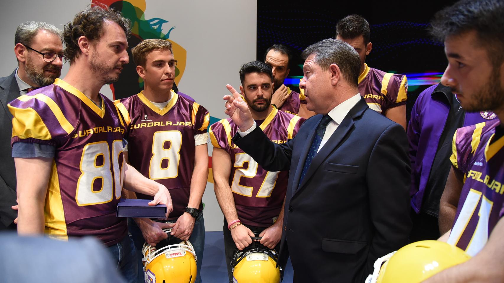 Emiliano García-Page conversa con un grupo de deportistas.