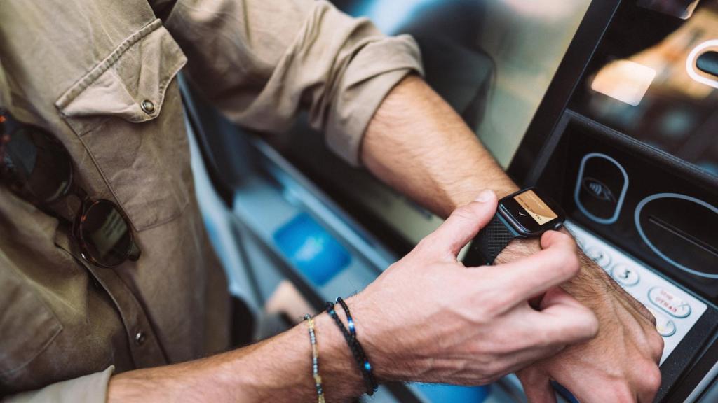 Persona usando un smartwatch para un cajero.