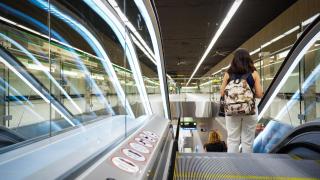 Una usuaria del Metro de Málaga baja por una de las escaleras eléctricas.