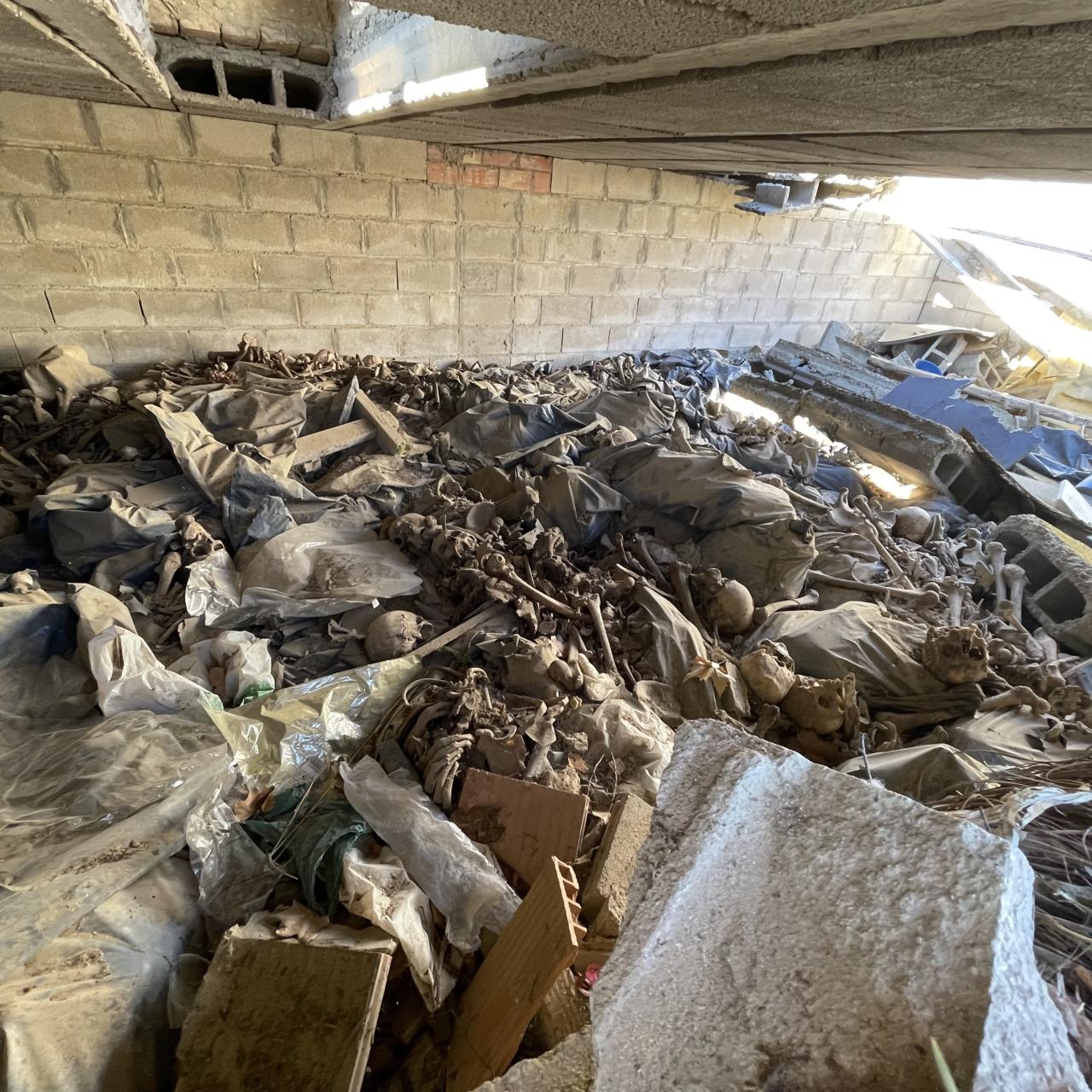 Imagen del osario, con los restos a la intemperie, entre rasillones de obra.