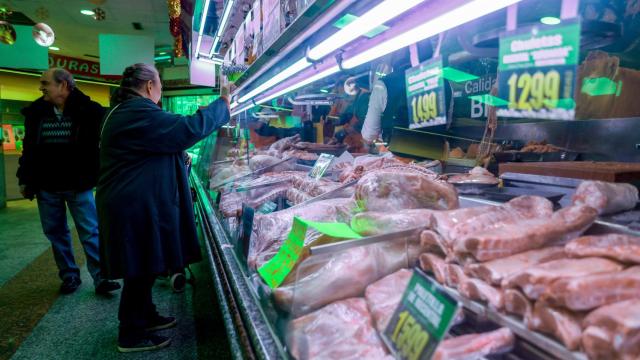 Varias personas comprando en una carnicería.