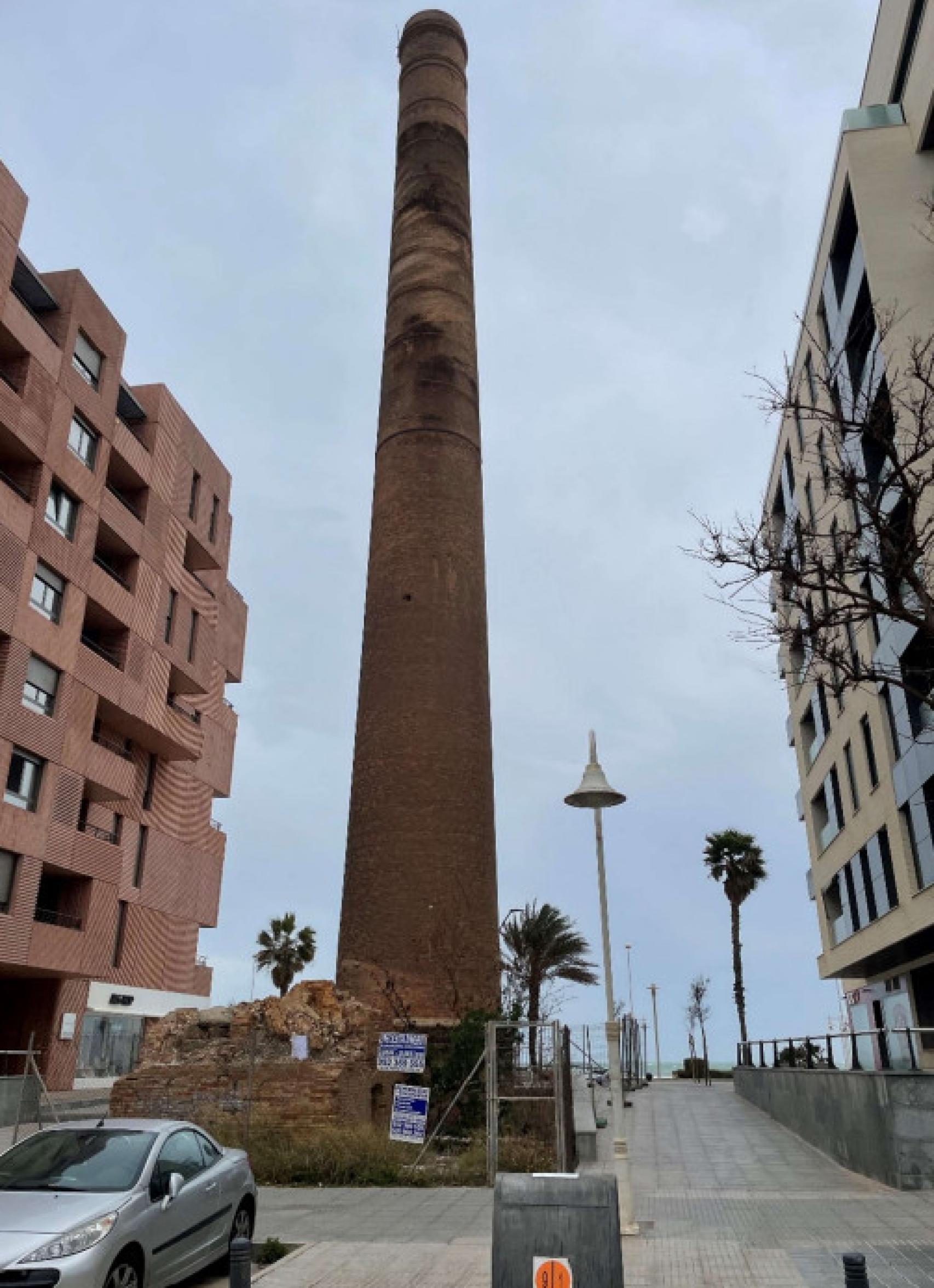 Chimenea Cros de Málaga, entre edificios del paseo del litoral oeste.