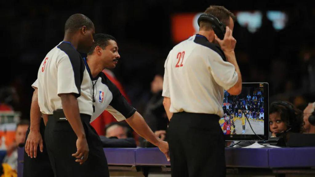 Árbitros consultando el instant replay en un partido de la NBA