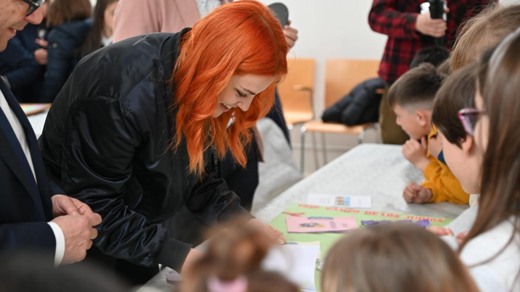 La astronauta Sara García ve los dibujos que han preparado los más pequeños.