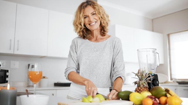 Una mujer, cortando fruta.