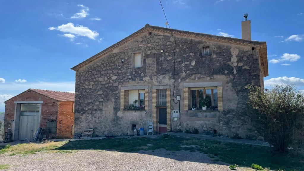 Vista principal de la casa donde Ricard reside con sus padres. A la derecha, una de las naves con material.
