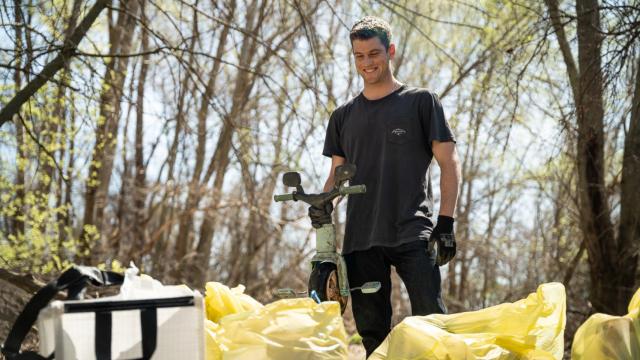 El actor Miguel Bernardeau sujeta el triciclo que ha encontrado en el cauce del río Jarama.