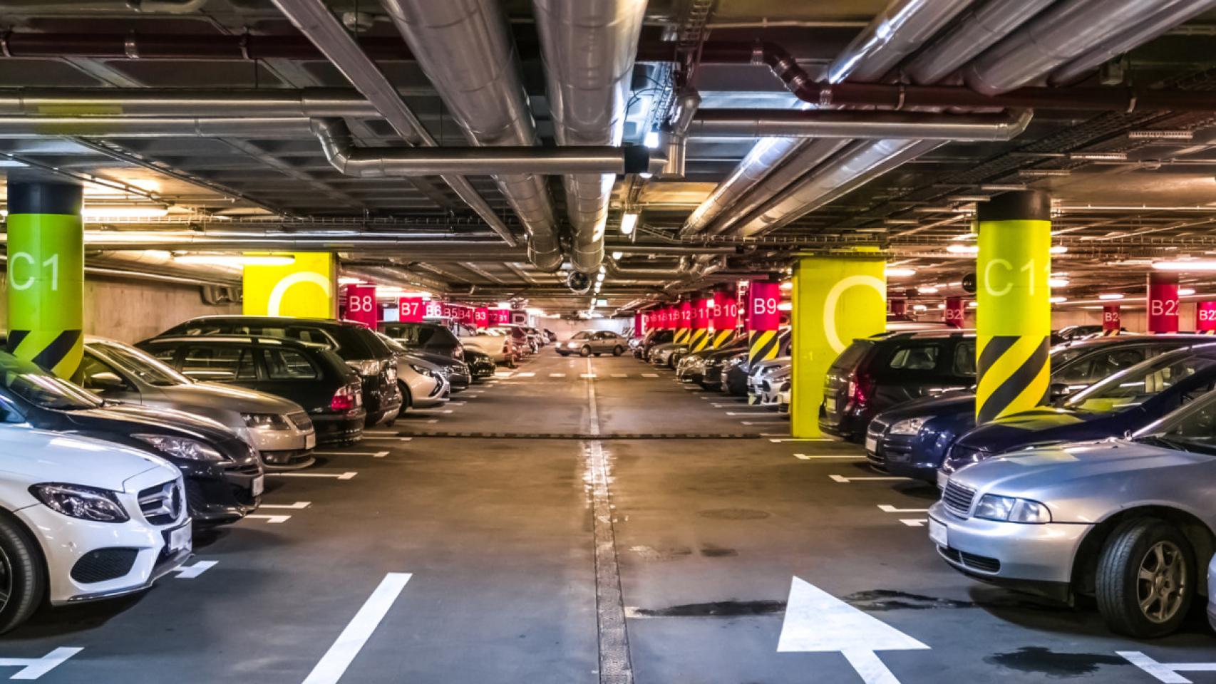 Varios vehículos estacionados en un garaje subterráneo.