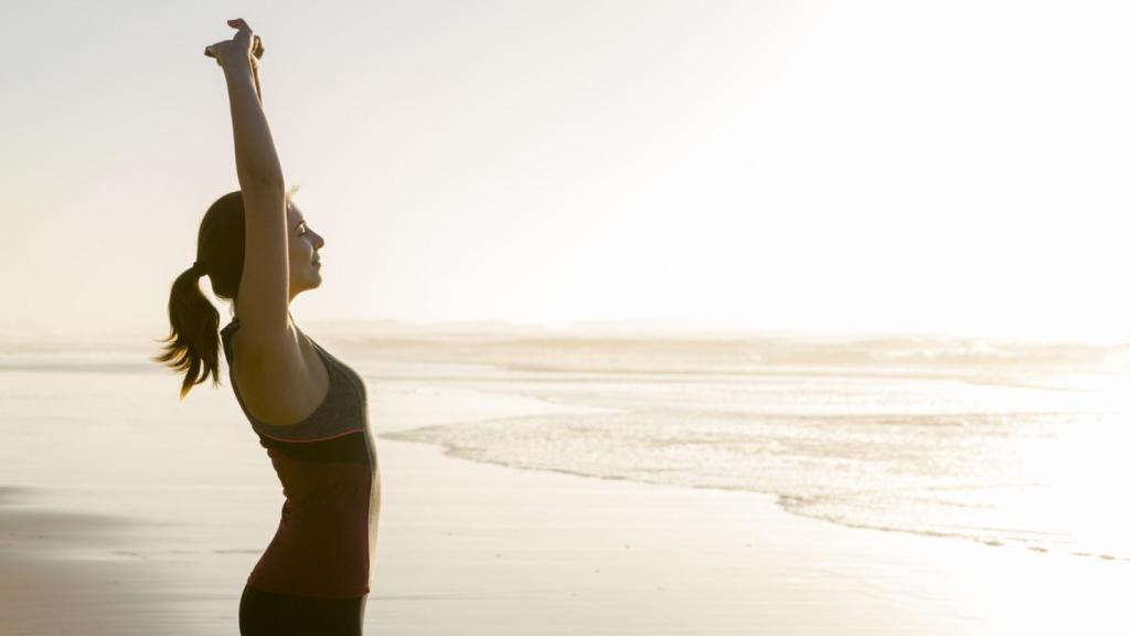 Mujer haciendo ejercicio en la playa.