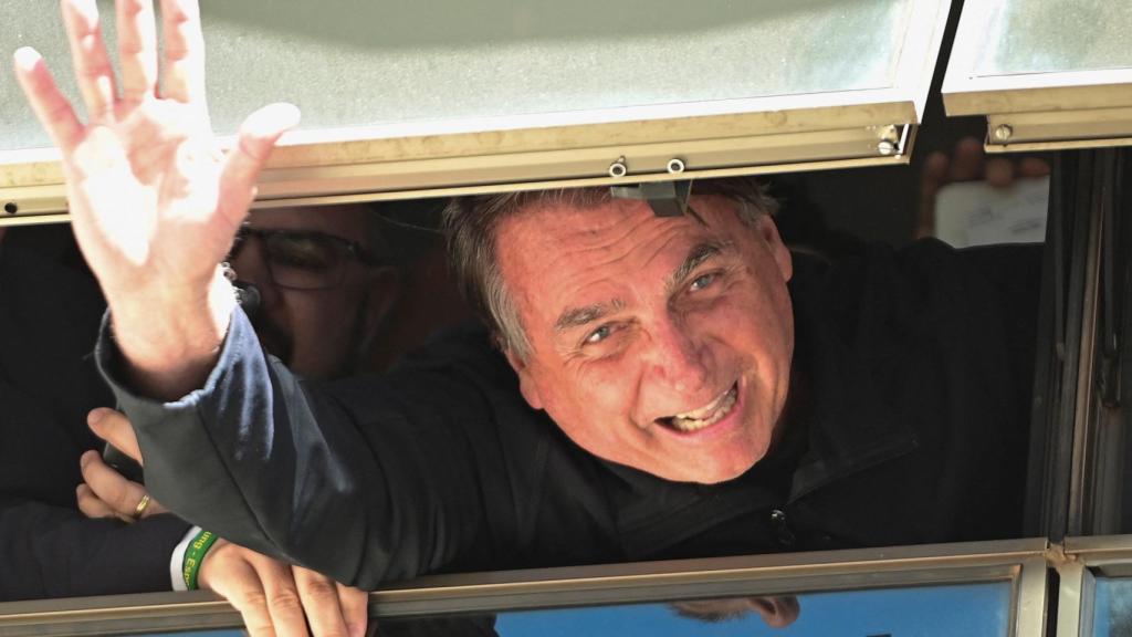 El expresidente Jair Bolsonaro saluda desde la sede del Partido Liberal en Brasilia, este jueves.