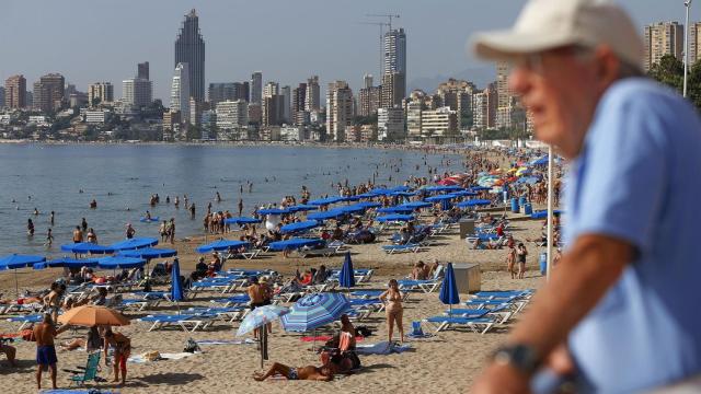 Turistas en la playa de Benidorm, con el 'skyline' de la ciudad al fondo.