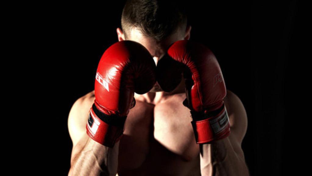 Un púgil se tapa el rostro con sus guantes de boxeo