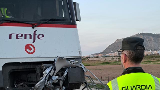 Un agente observa el tren tras chocar con el vehículo en Cullera (Valencia).