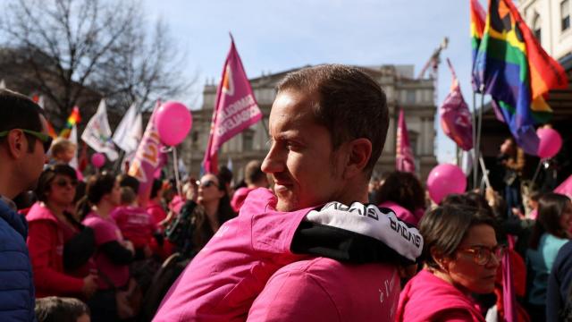 Una padre sostiene a su hija en una protesta contra las medidas de Meloni en Milán, este marzo.