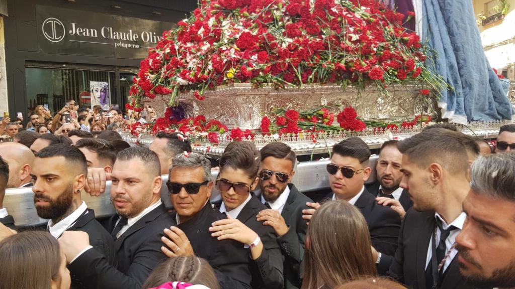 Los hombres de trono llevan las andas de traslado.