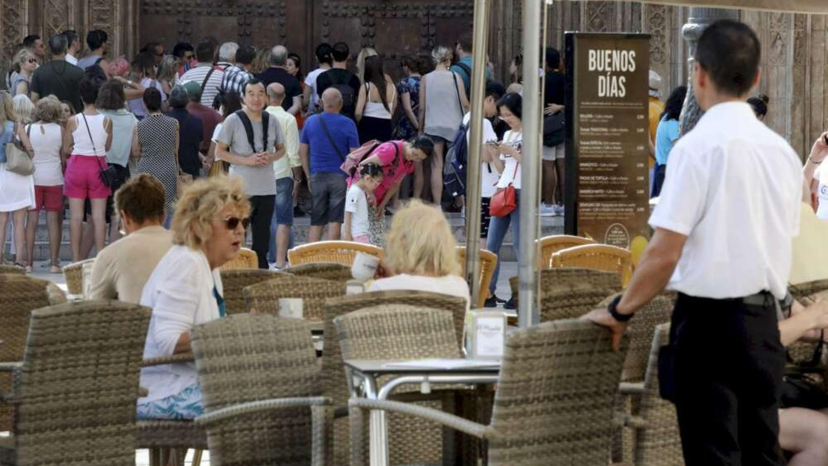 Un camarero observa a decenas de turistas, en imagen de archivo.