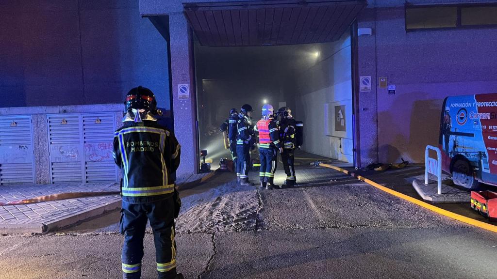 Dotaciones de bomberos apagando el fuego de la nave.