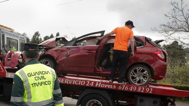 Un Guardia Civil vigila la retirada del coche siniestrado, en el accidente de Xove (Lugo).