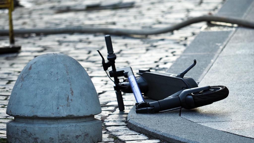 Un patinete eléctrico tirado en la acera.
