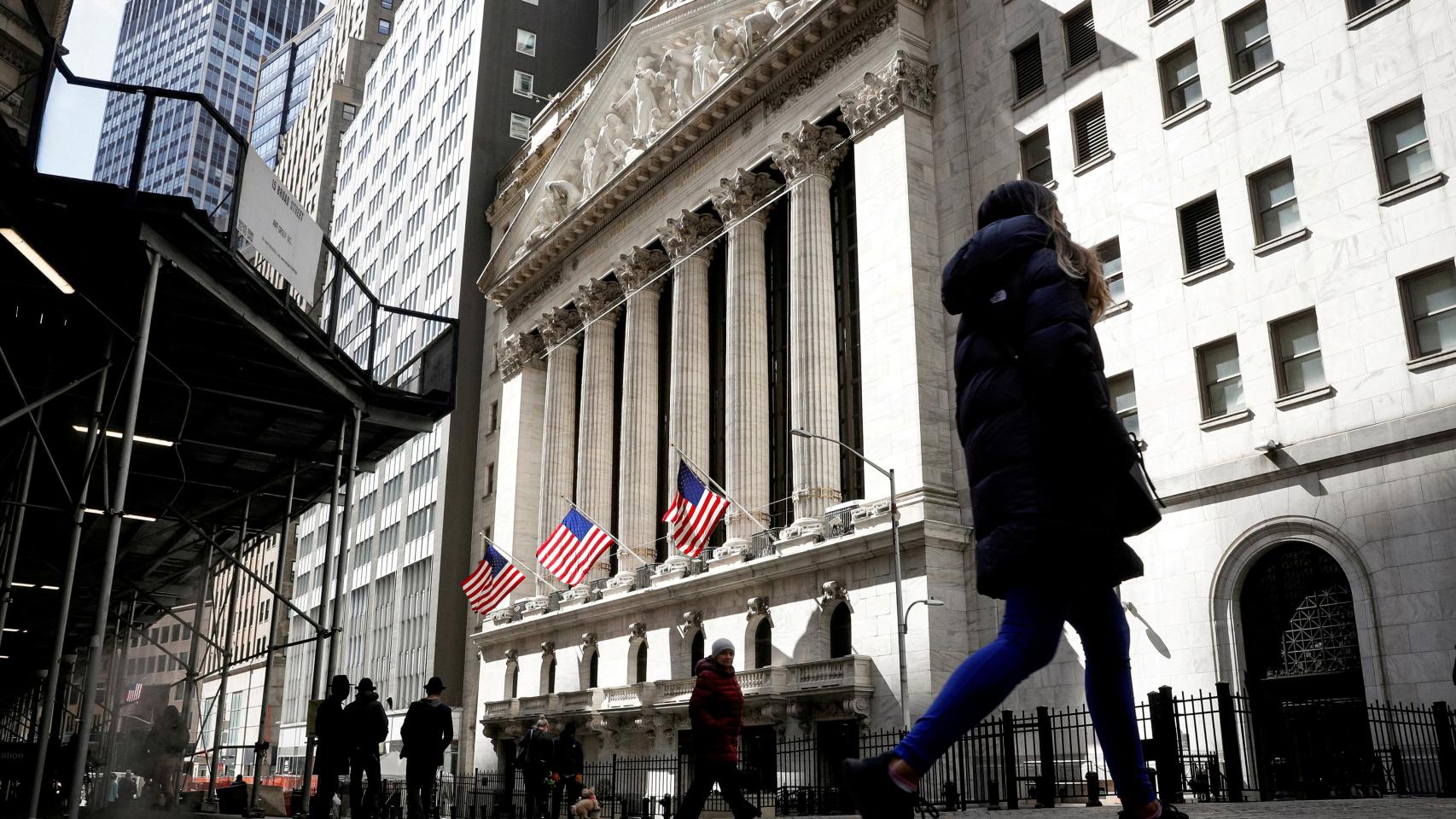 Personas pasean por Wall Street ante el edificio de la Bolsa de Nueva York.