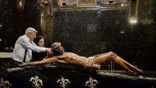 Ramón y Marta prueban la corona de espinas al Cristo de la Buena Muerte.