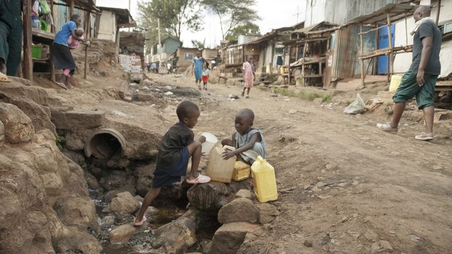 Imagen de archivo de dos niños recogiendo agua en una calle de Kibera en Nairobi (Kenia).