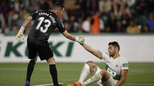 Edgar Badia ayuda a su compañero Pedro Bigas en el partido del Elche contra el Barcelona.