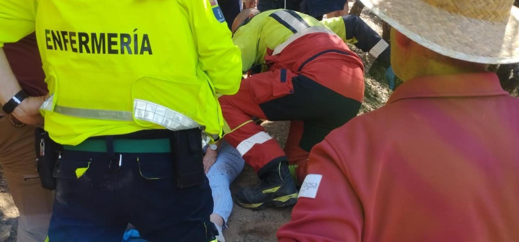 Bomberos y sanitarios atendiendo a la senderista en el lugar de la caída.