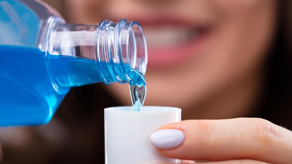 Una joven utiliza un colutorio para mantener su salud bucal en perfecto estado.