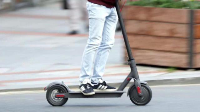 Imagen de archivo de una persona montando en patinete.