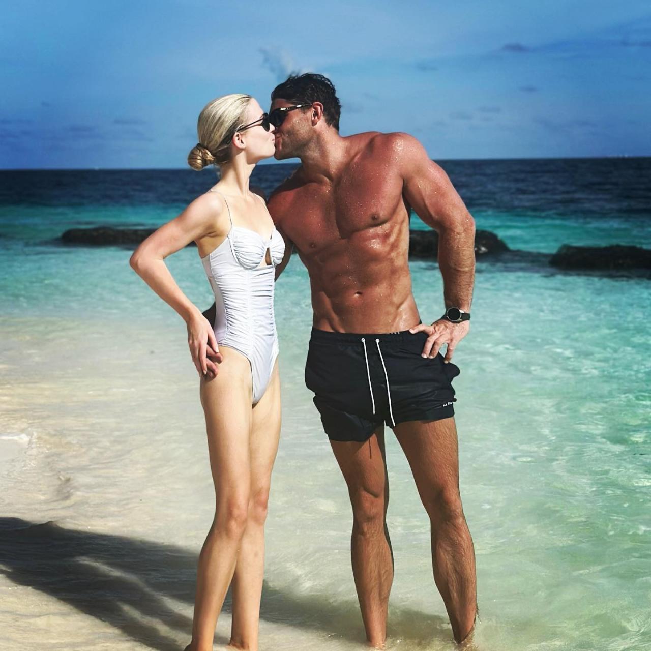 Los recién casados se besan en la playa de Maldivas.