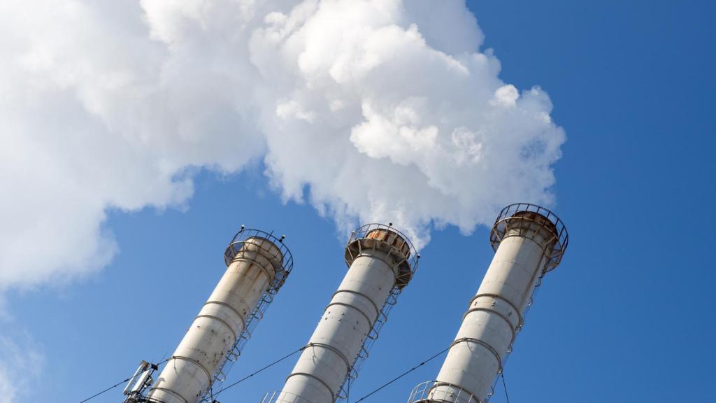 Unas chimeneas expulsan humo con contaminantes del aire.