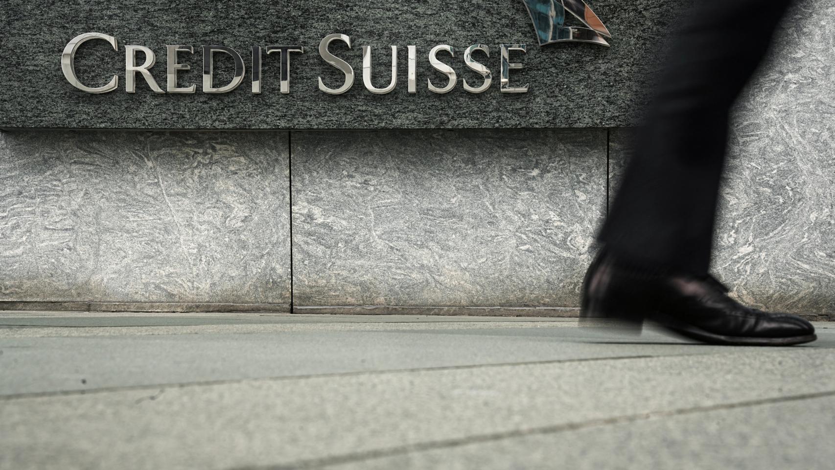 Una persona camina delante de la sede de Credit Suisse en Hong Kong.