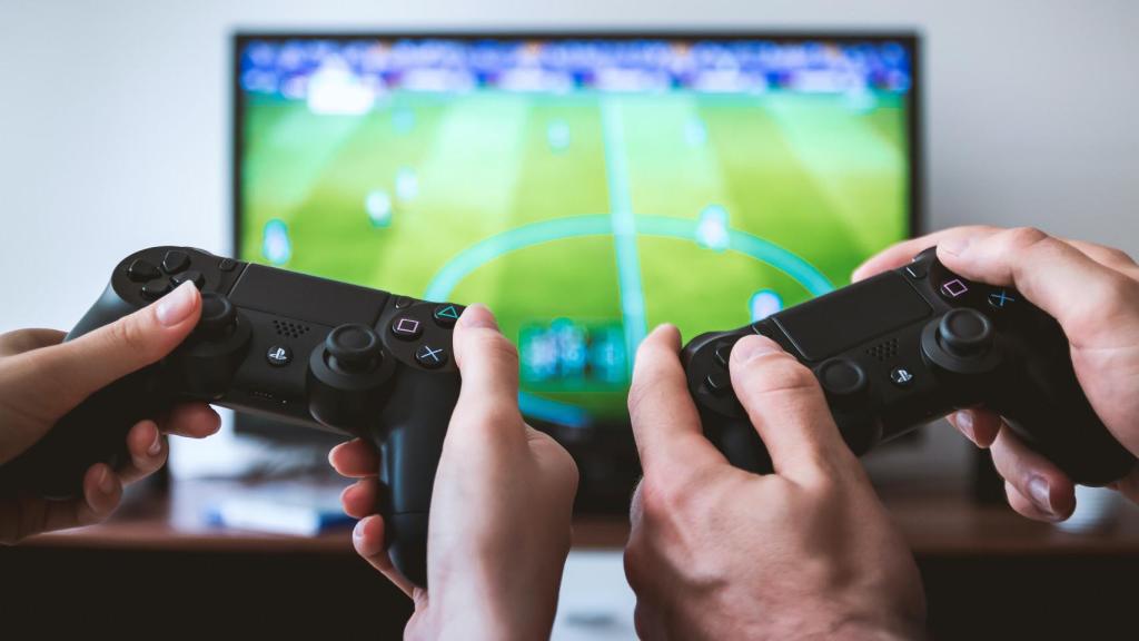 Dos personas jugando a la PlayStation.
