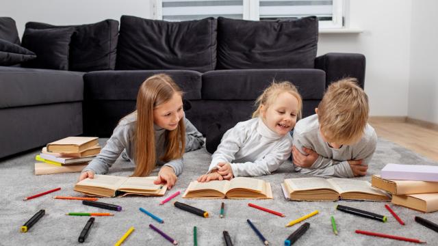 Tres hermanos pintando y leyendo.