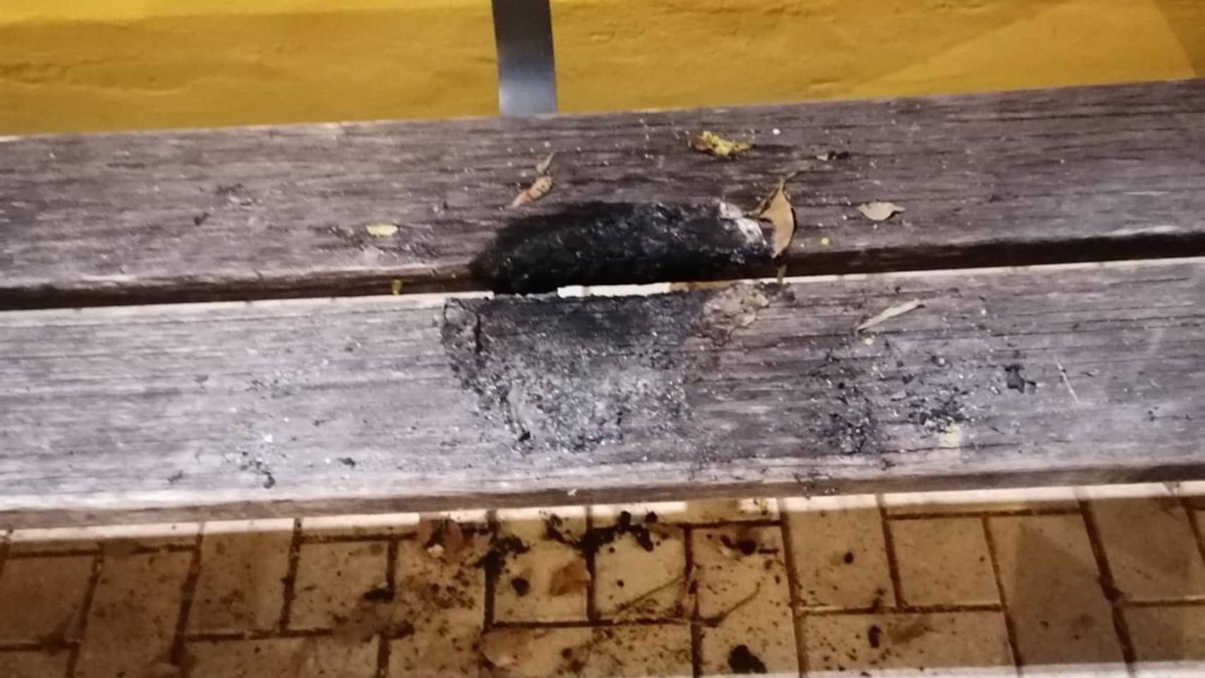 La parte del banco de madera que resultó quemada.
