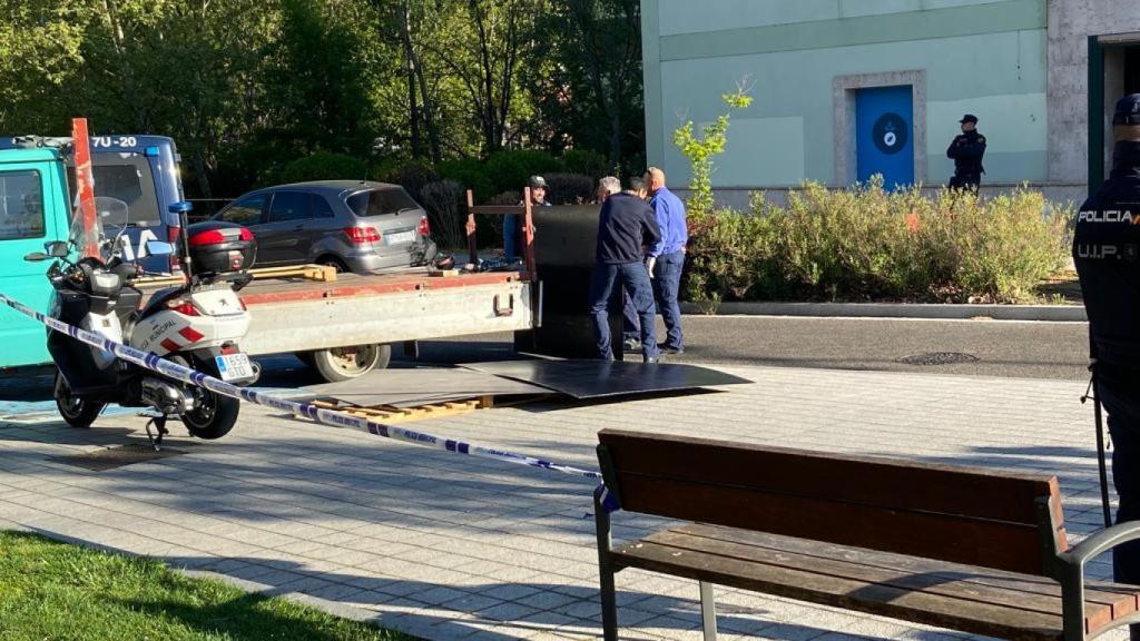Unos operarios cogen unas planchas de metal para tapiar La Molinera.
