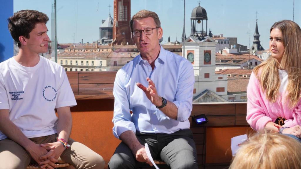 Alberto Núñez Feijóo, este martes en Madrid con dos jóvenes de Nuevas Generaciones.