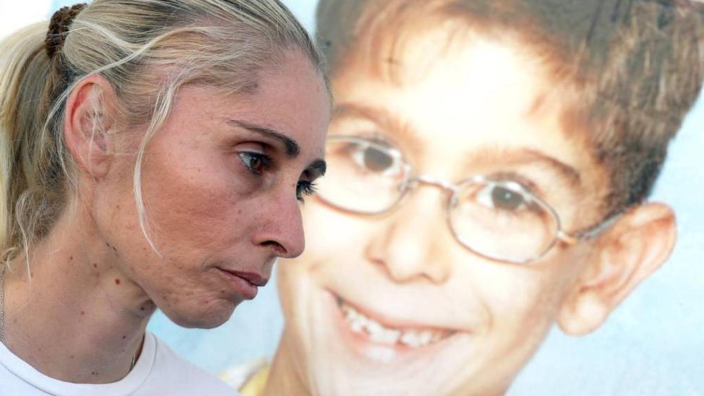 Ithaisa Suárez en 2021, junto a un póster de su hijo desaparecido, Yéremi.