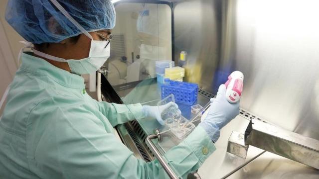 Una investigadora manipula una pipeta en un laboratorio.