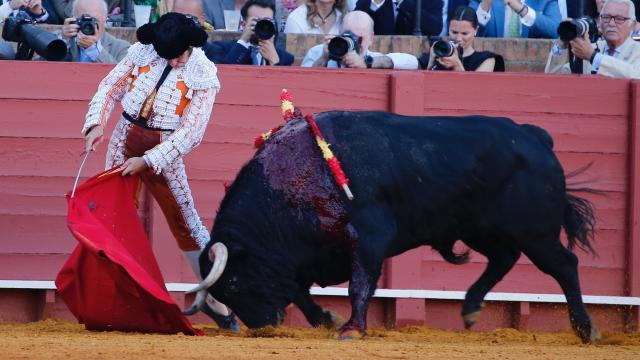 Morante de La Puebla pega un muletazo en Sevilla con la montera puesta.