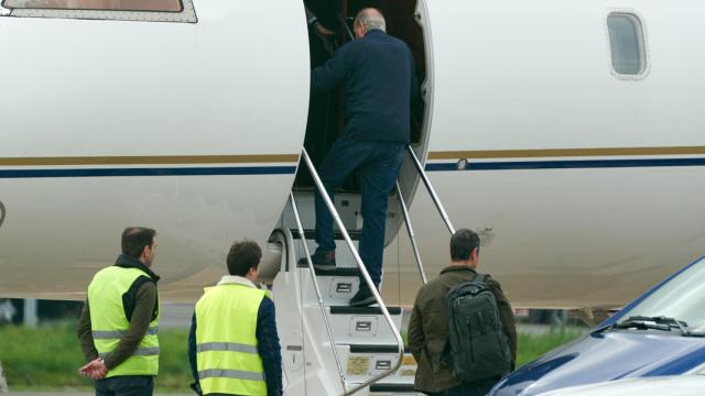 El Rey emérito Juan Carlos I sube las escaleras de un avión privado en el aeropuerto vitoriano de Foronda.