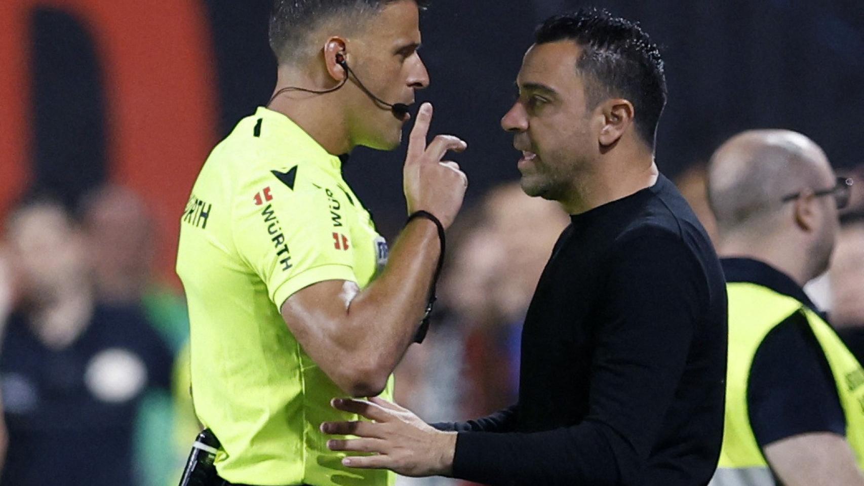 El árbitro Gil Manzano, debatiendo con Xavi Hernández en la banda